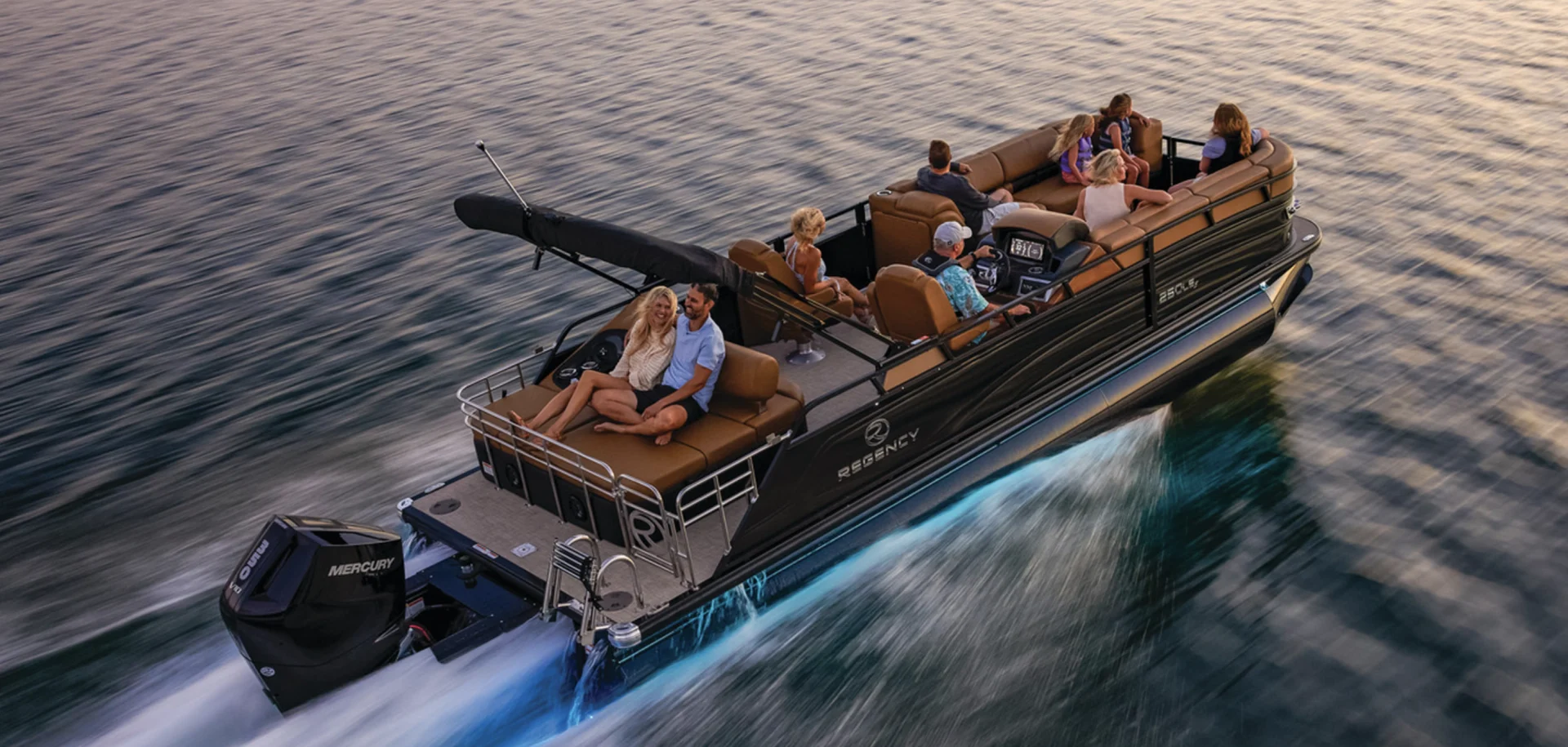 Regency luxury pontoon boat cruising on open water with passengers relaxing, highlighting Regency pontoons for premium leisure boating at Grand Pointe Marina