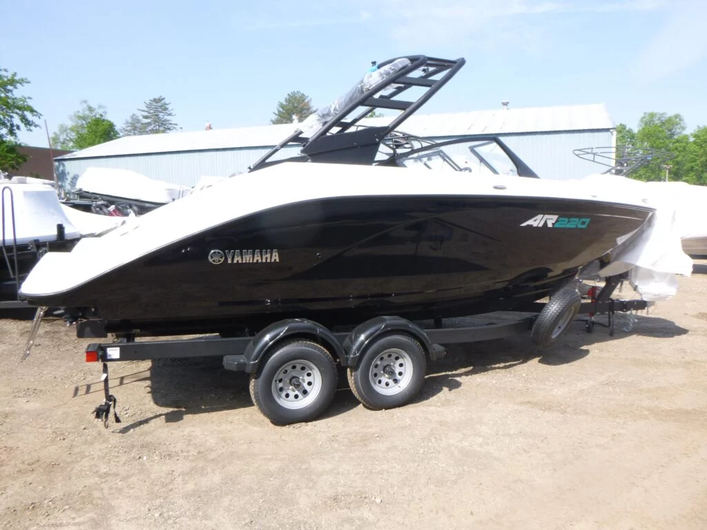 2025 Yamaha Boats AR220 jet boat with black hull and wakeboard tower on tandem-axle trailer