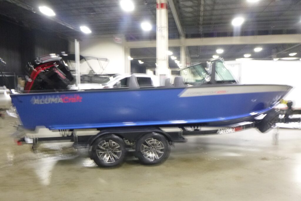 2026 Alumacraft Competitor 205 Sport aluminum fishing boat on trailer indoors