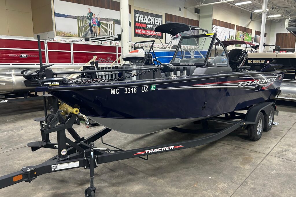 2024 Tracker Targa V-18 Combo fishing boat on trailer with dark blue hull, bimini top, and trolling motor